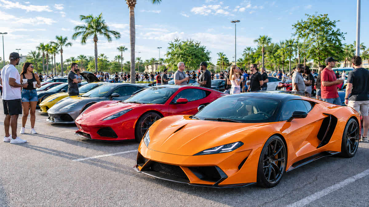 Diverse car enthusiasts gather around colorful exotic supercars at a morning Cars and Coffee event in Orlando.